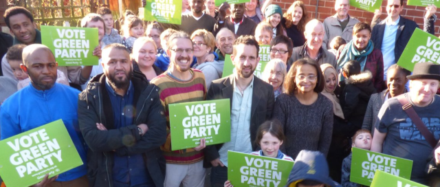Alaric in a group holding 'Vote Green Party' signs